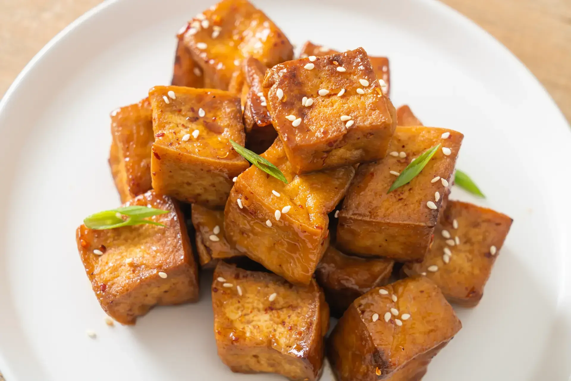 Pritong tokwa na may sesame seeds na nasa puting pinggan.